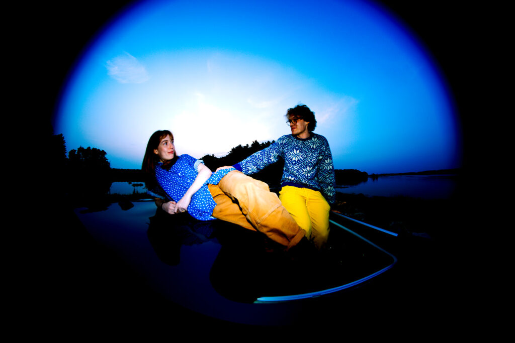 a couple on the top of their car posing for their engagement session 